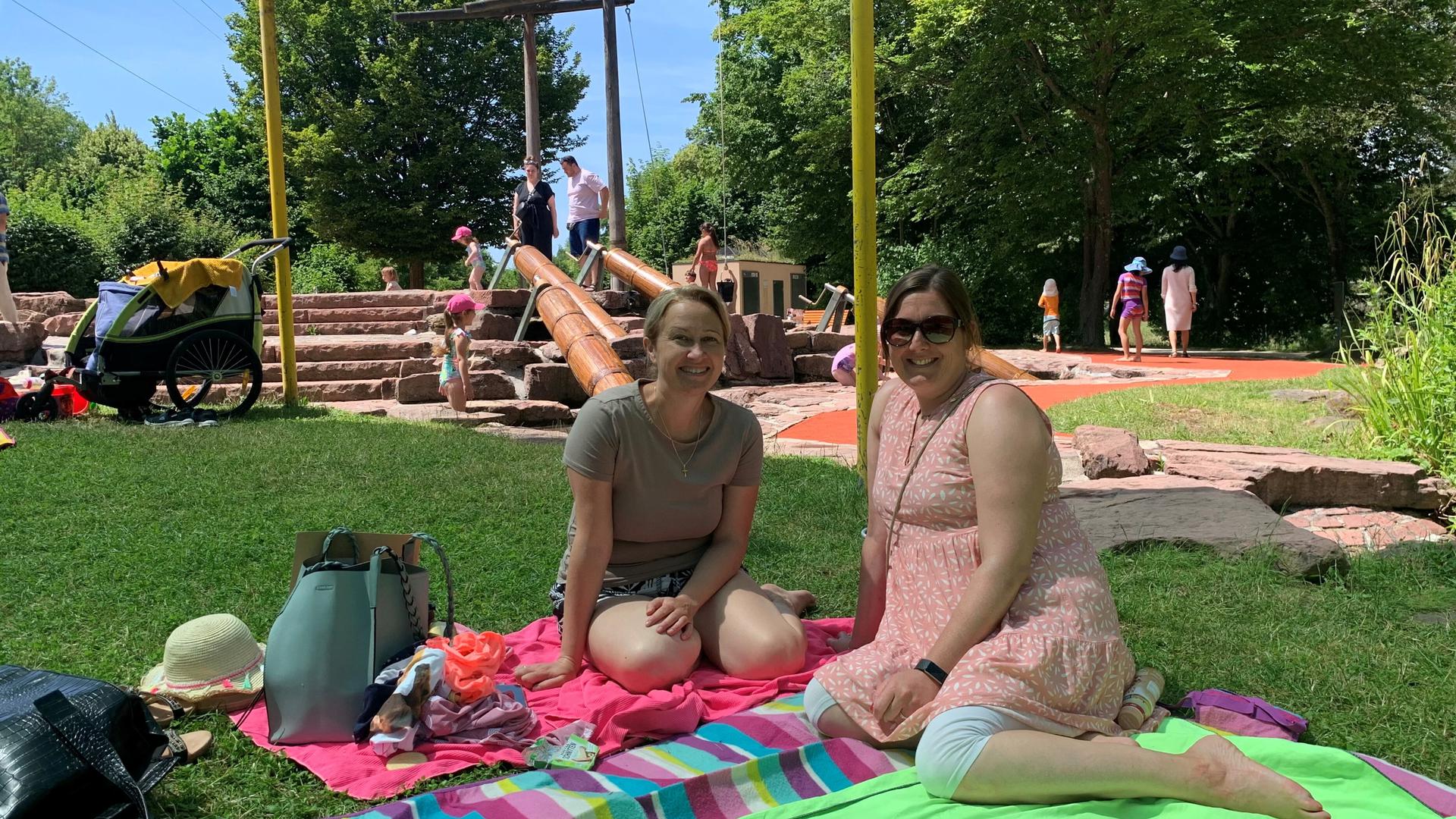 Zwei Frauen sitzen auf einer Picknickdecke