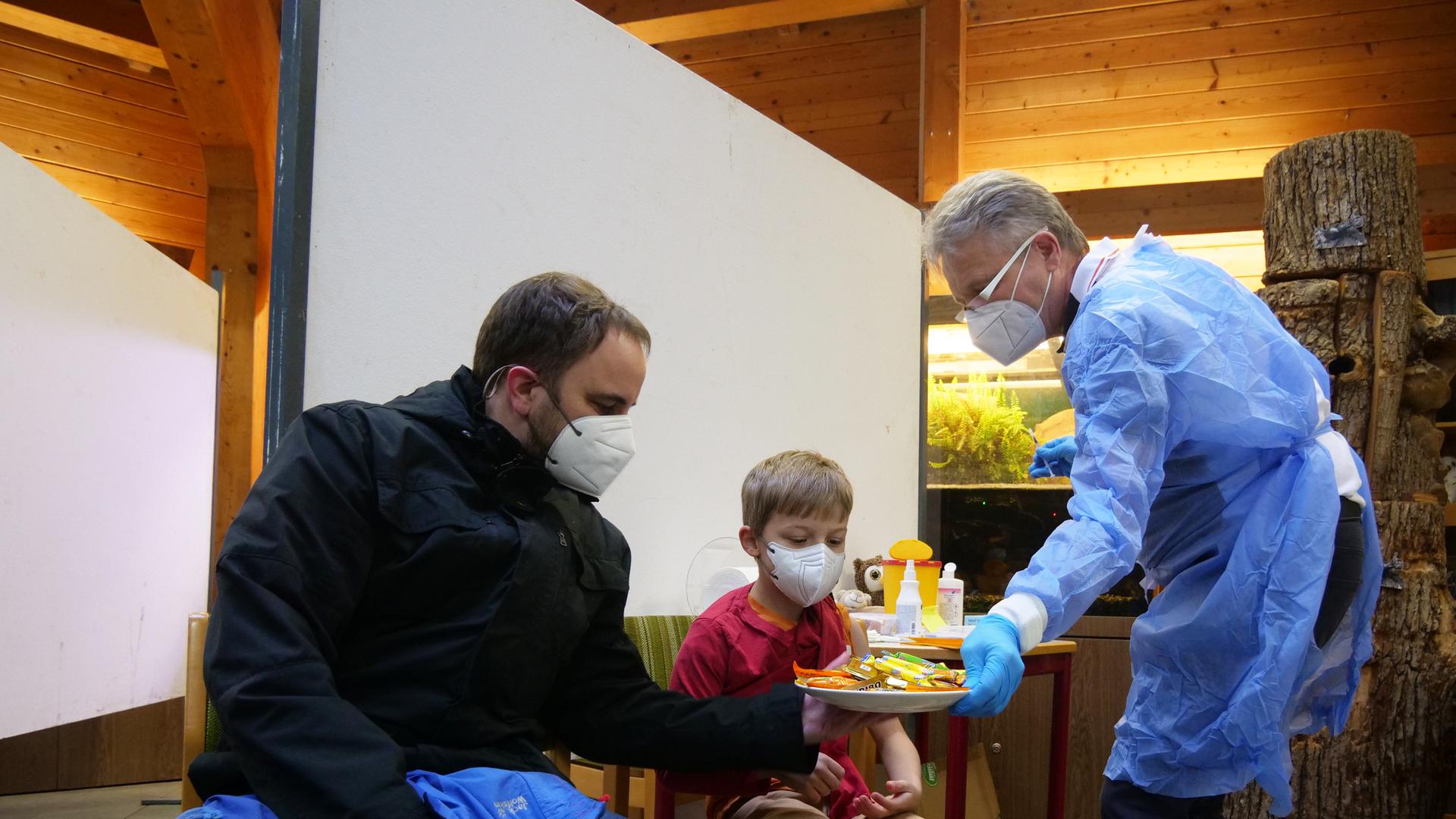 Für die jüngsten Besucher hatte Impfarzt Uwe Hassepaß (rechts) bei der Familien-Impfaktion im Wildpark eine süße Belohnung parat