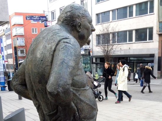 Im Tageslicht fühlt sich „Der Dicke“, der am Eingang zur Fußgängerzone auf den Leopoldplatz blickt, derzeit nicht wohl, denn er trauert: Sein Schöpfer, der Bildhauer Karl-Henning Seemann ist gestorben.
