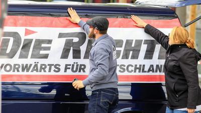 Mit der Rechten: Aktivisten der Partei „Die Rechte“ bekleben vor einer Demonstration in Pforzheim ein Banner auf einen Kleinbus.