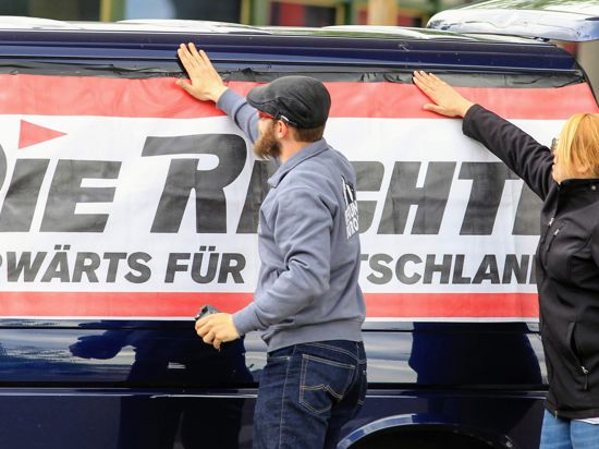 Mit der Rechten: Aktivisten der Partei „Die Rechte“ bekleben vor einer Demonstration in Pforzheim ein Banner auf einen Kleinbus.