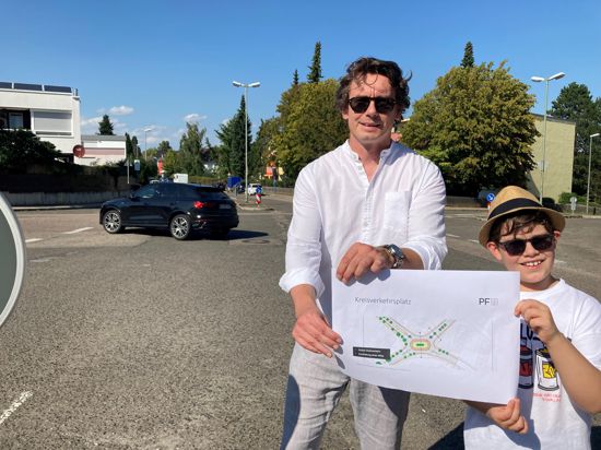 Der Vorsitzende des Bürgervereins Rodrücken Pforzheim und sein Sohn Ben halten einen Plan vom geplanten Kreisverkehr an der Kreuzung Vogesenallee und Postwiesenstraße.