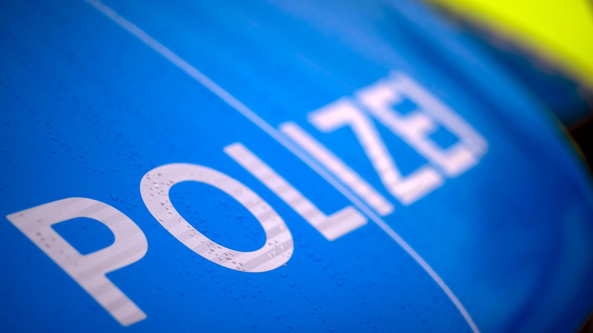 Der Schriftzug „Polizei“ steht auf einem Streifenwagen.