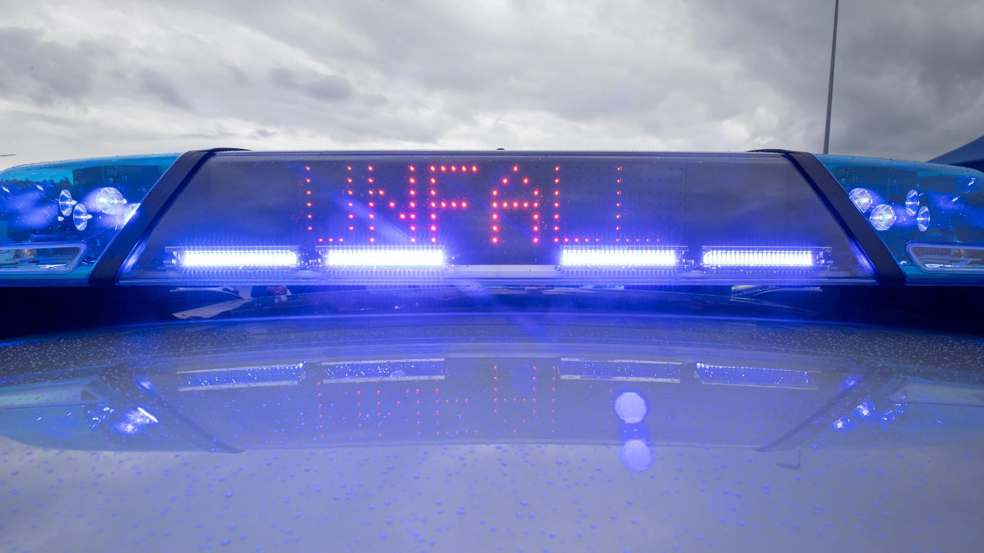 Ein Blaulicht und eine LED-Anzeige leuchten auf dem Dach eines Polizeifahrzeugs.