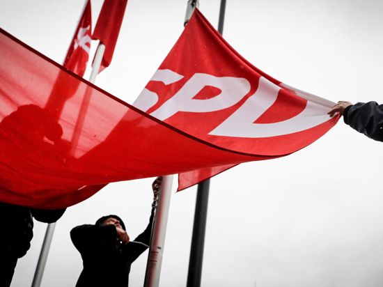  Fahnen mit dem SPD-Logo werden am 20.01.2018 vor der Parteitagshalle in Bonn (Nordrhein-Westfalen) im Regen hochgezogen.  CDU/CSU statt. Foto: Kay Nietfeld/dpa +++ dpa-Bildfunk +++ | Verwendung weltweit