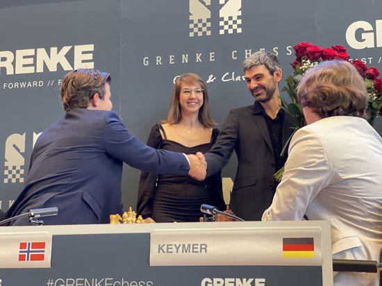 Magnus Carlsen (links) gratuliert Ilja Schneider und dessen künftiger Braut Olga Ivanova zur Verlobung.