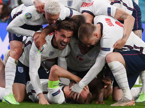 England's forward Harry Kane (bottom) celebrates with teammates after scoring a goal during the UEFA EURO 2020 semi-final football match between England and Denmark at Wembley Stadium in London on July 7, 2021. / AFP / POOL / Laurence Griffiths