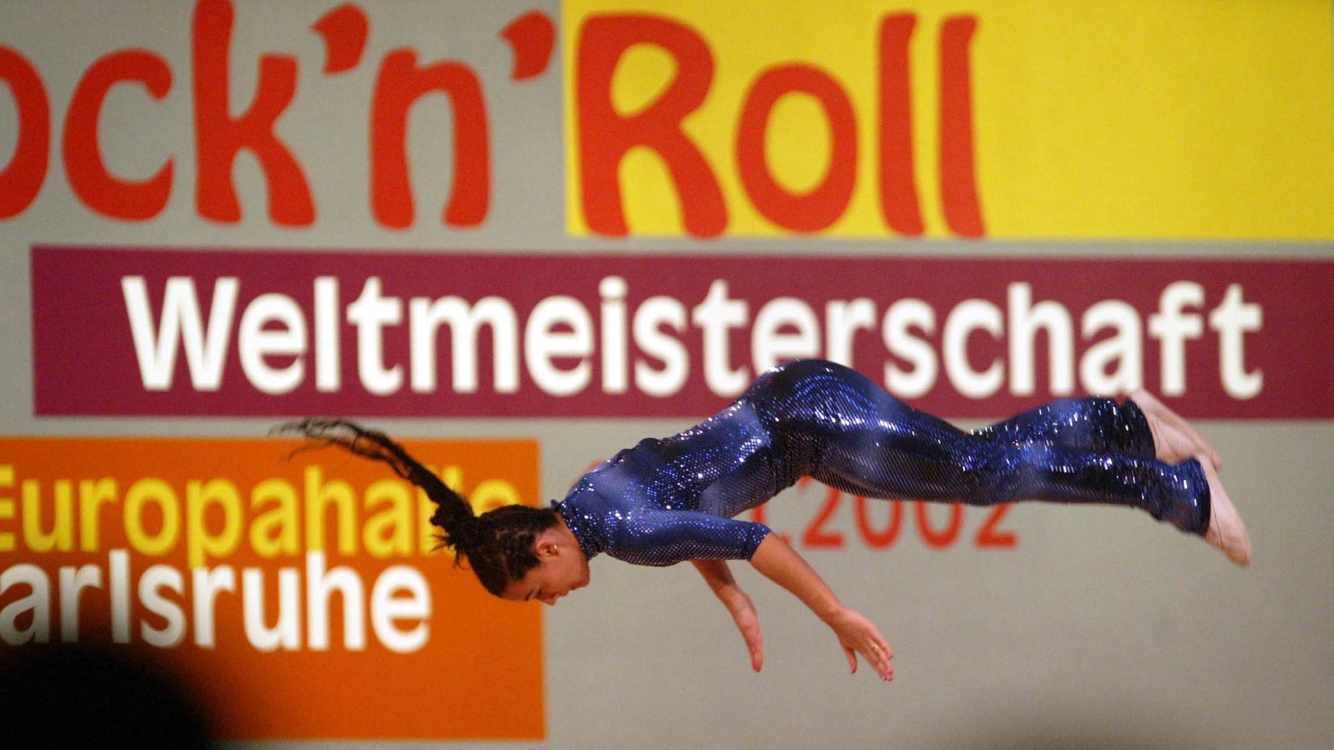 Tänzerin vor Logo der  Rock’n’Roll Weltmeisterschaften in Karslruhe.