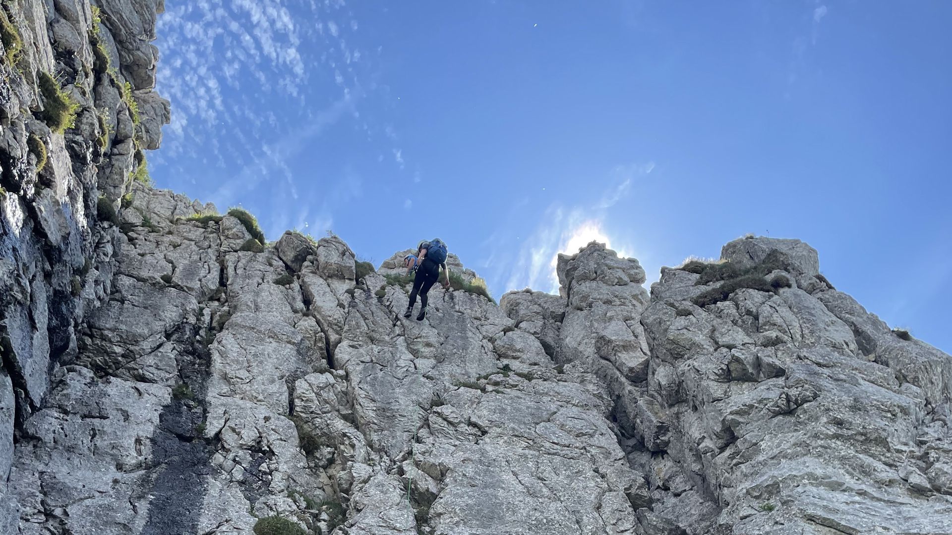 Eine Frau lässt sich an einer Steilwand in den Allgäuer Alpen von einem Bergführer abseilen.