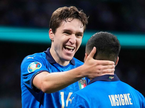 Italy's midfielder Federico Chiesa (L) celebrates his opening goal with Italy's forward Lorenzo Insigne during the UEFA EURO 2020 semi-final football match between Italy and Spain at Wembley Stadium in London on July 6, 2021. / AFP / POOL / Frank Augstein