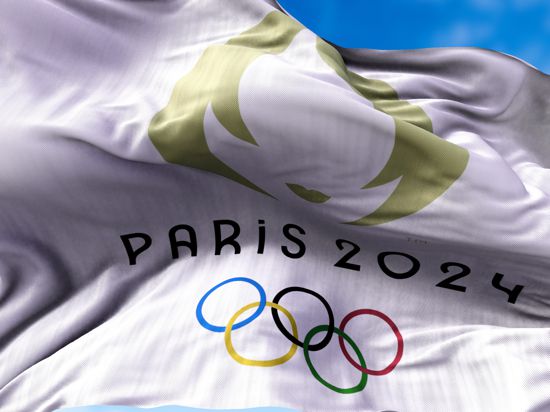 Eine Fahne mit der Aufschrift „Paris 2024“, den olympischen Ringen und dem Symbol für die Sommerspiele 2024 weht im Juli 2021 in Tokio im Wind.
