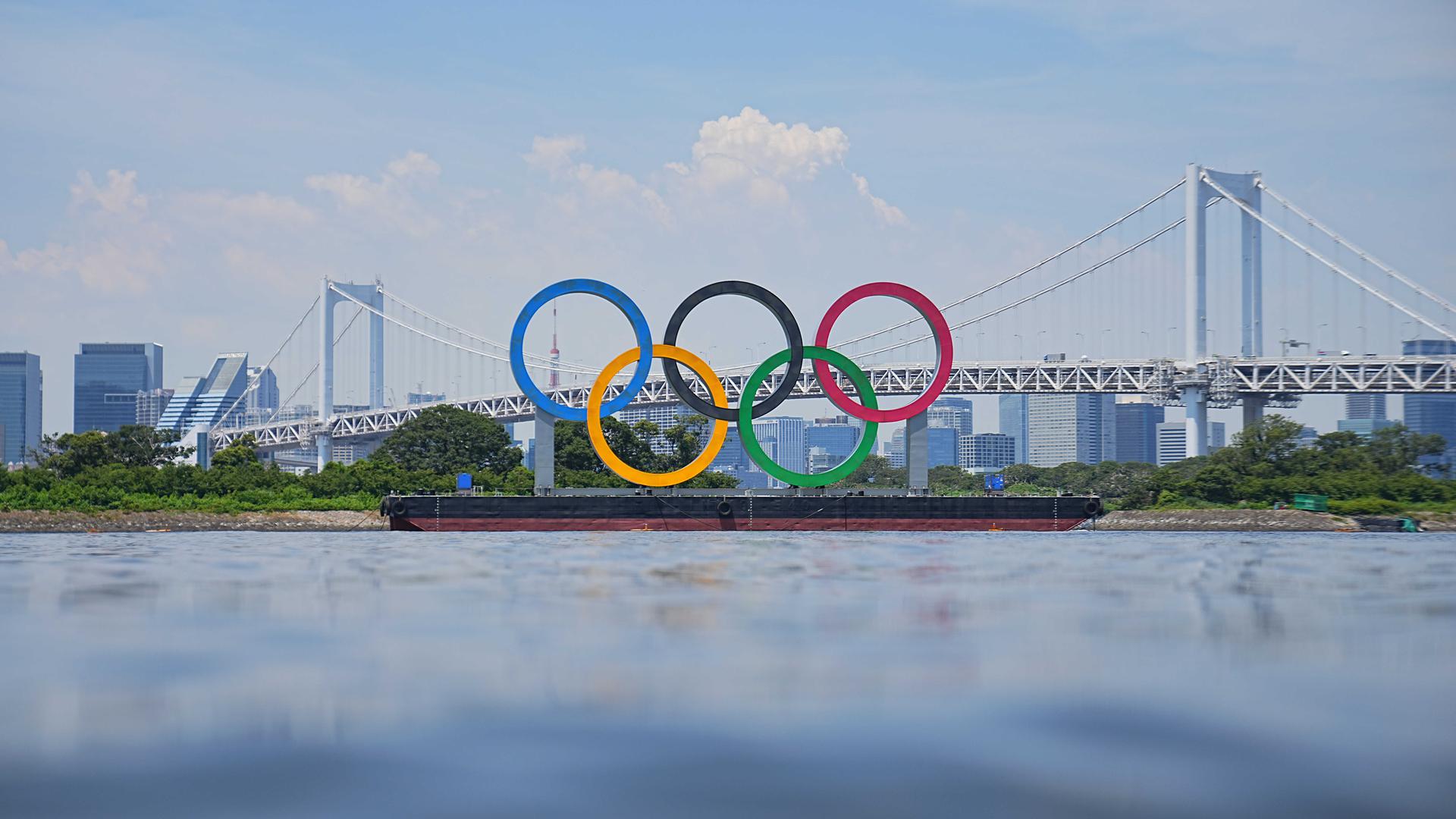 Ein Blick auf olympischen Ringe vor der Rainbow Bridge. Die Ringe stehen auf einem Ponton in der Bucht von Tokio.