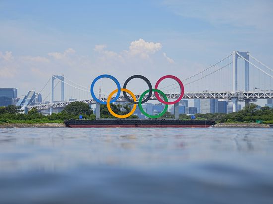 Ein Blick auf olympischen Ringe vor der Rainbow Bridge. Die Ringe stehen auf einem Ponton in der Bucht von Tokio.
