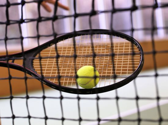 Symbolbild: Nahaufnahme von einem Tennisschläger mit Ball in einer Tennishalle *** Symbol image close-up of a tennis racket with ball in a tennis hall 