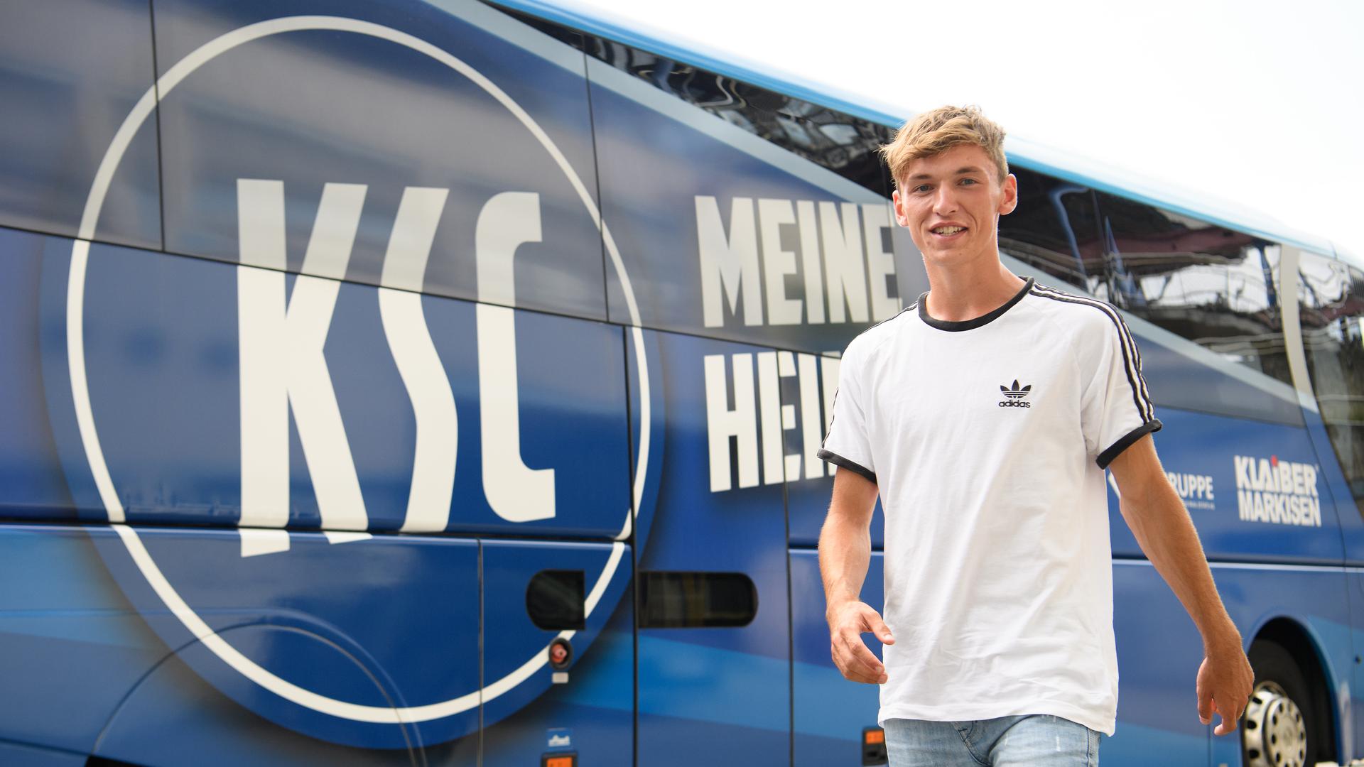 KSC-Neuzugang Benjamin Goller läuft im Wildparkstadion an einem Bus mit dem Logo des Karlsruher SC vorbei.