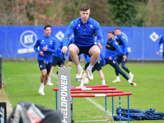 Daniel O´Shaughnessy, hinter dem zwei Hüftoperationen liegen, springt über eine Kleinhürde, während seine Mitspieler vom Karlsruer SC im Hintergrund trainieren. 