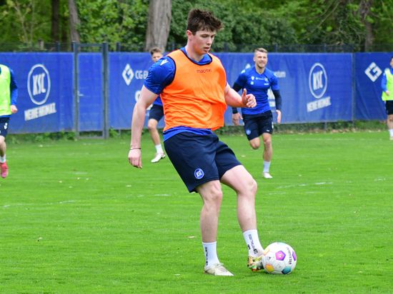 Daniel O’Shaughnessy hat im Kreise seiner Teamkollegen beim Training des Karlsruher SC den Ball am Fuß.