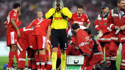 Beklemmende Momente im Wildpark: Kölns Torwart Faryd Mondragon wendet sich ab. Der am Boen liegende Umit Özat wird am 29. August 2008 von einem Pulk von Sanitätern und Spielern umringt.