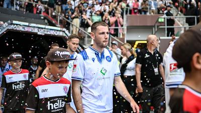 Leon Jensen läuft vor dem letzten Saisonspiel am Millerntor im Konfettiregen zu „Hells bells“ mit der Karlsruher Mannschaft ein. 