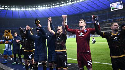 Die Mannschaft des Karlsruher SC feiert nach dem 2:2 im Berliner Olympiastadion mit ihren rund 5.000 mitgereisten Fans einen Punkt, der ausreichte, um mit Anbruch der Länderspielpause den Relegationsplatz zu verlassen.  