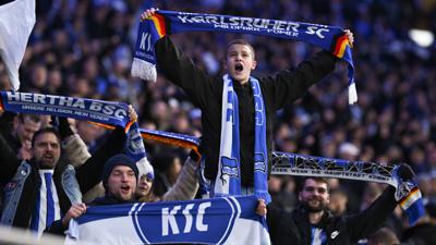 Fans des Karlsruher SC feiern im Olympiastadion einträchtig mit Anhängern der Hertha.  