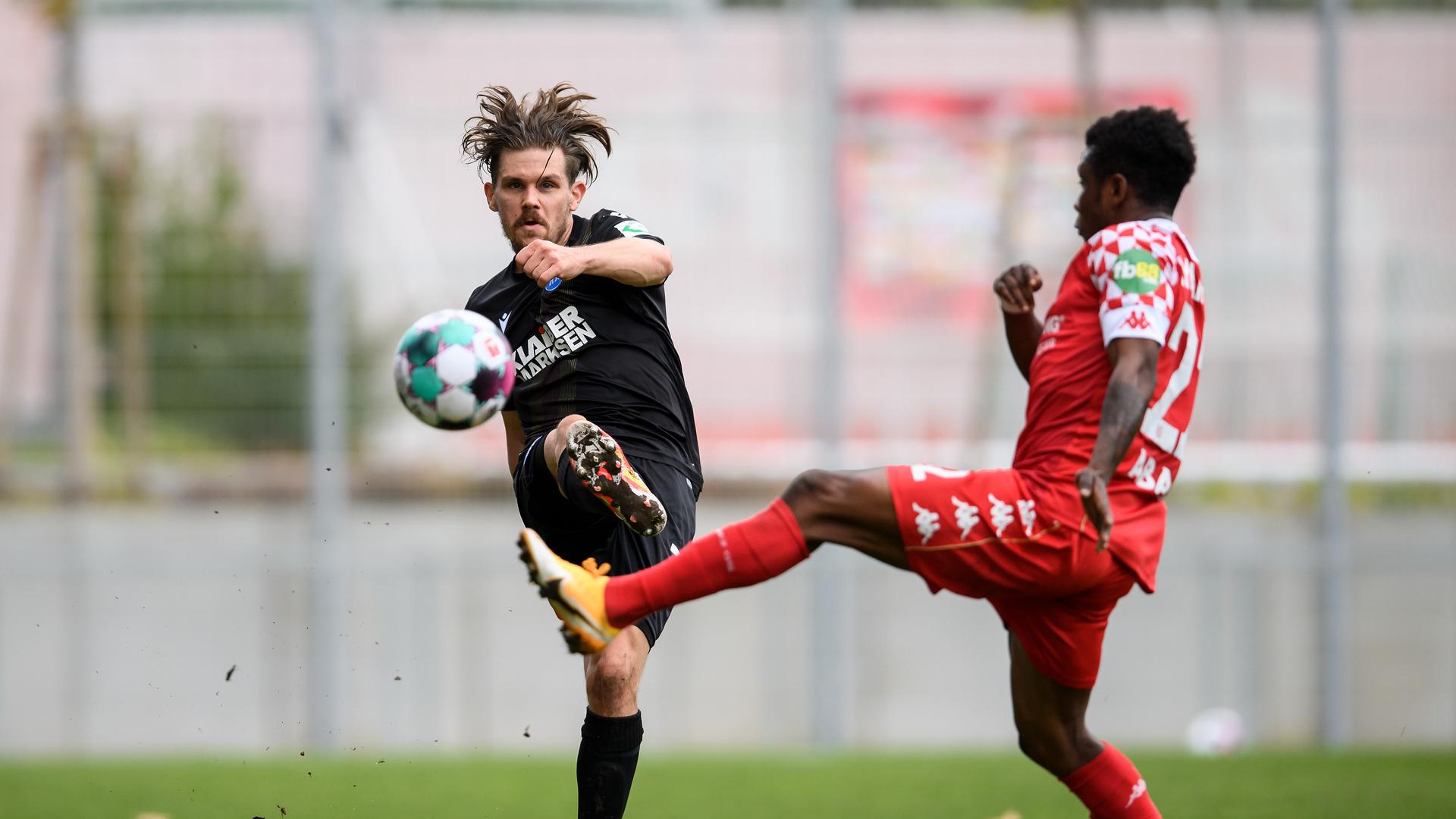 Debütant im KSC-Dress: Sebastian Jung (links), angegriffen vom Mainzer Abass Issah, spielt den Ball zu einem Mitspieler weiter. 