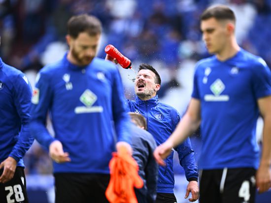 Jérôme Gondorf (KSC) trinkt vor dem Spiel des Karlsruher SC beim FC Schalke 04. Im Vordergrund sind Budu Zivzivadze (links) und Marcel Beifus zu sehen.