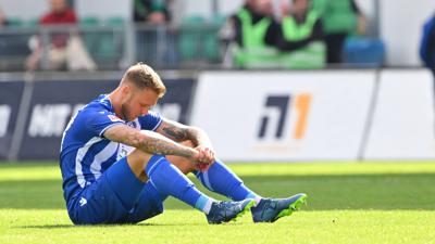 Innenverteidiger Marcel Franke sitzt nach der 3:4-Niederlage mit dem Karlsruher SC bei der Spvv Greuther Fürth enttäuscht auf dem Rasen des Spielfeldes. 