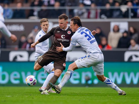 Johannes Eggestein lässt sich von Dzenis Burnic (hinten) und von Robin Bormuth nicht daran hindern, den Ball zum zwischenzeitlichen Ausgleich für den FC St. Pauli ins Tor zu wuchten.  