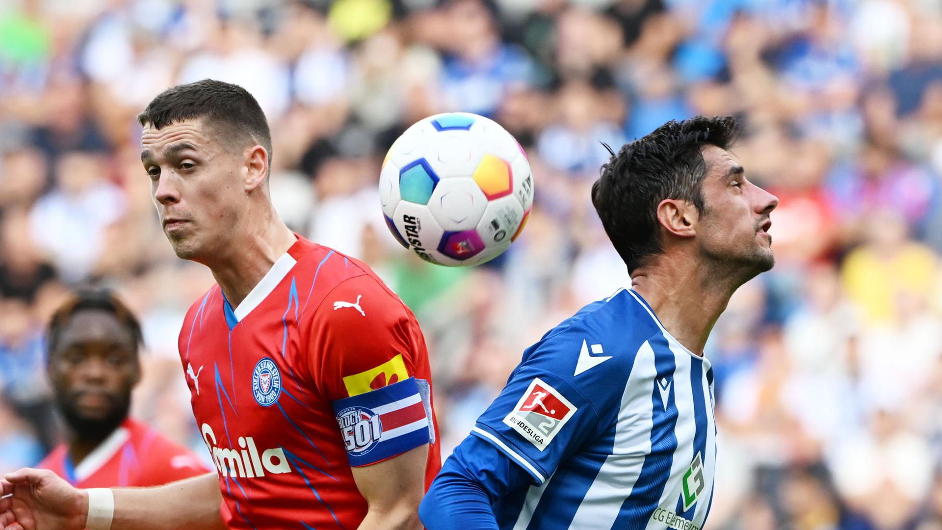 Der Karlsruher Lars Stindl (r) und der Kieler Philipp Sander kämpfen um den Ball. 