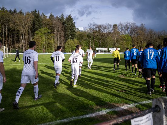 Die Fußballmannschaften des FC Eggenstein und des FC West laufen vor dem Spielbeginn auf das Spielfeld.