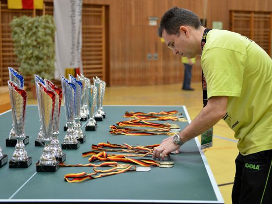Christian Gerwig, der Vorsitzende des TTV Ettlingen, legt bei den deutschen Schülermeisterschaften 2015 in Ettlingen die Medaillen zurecht.