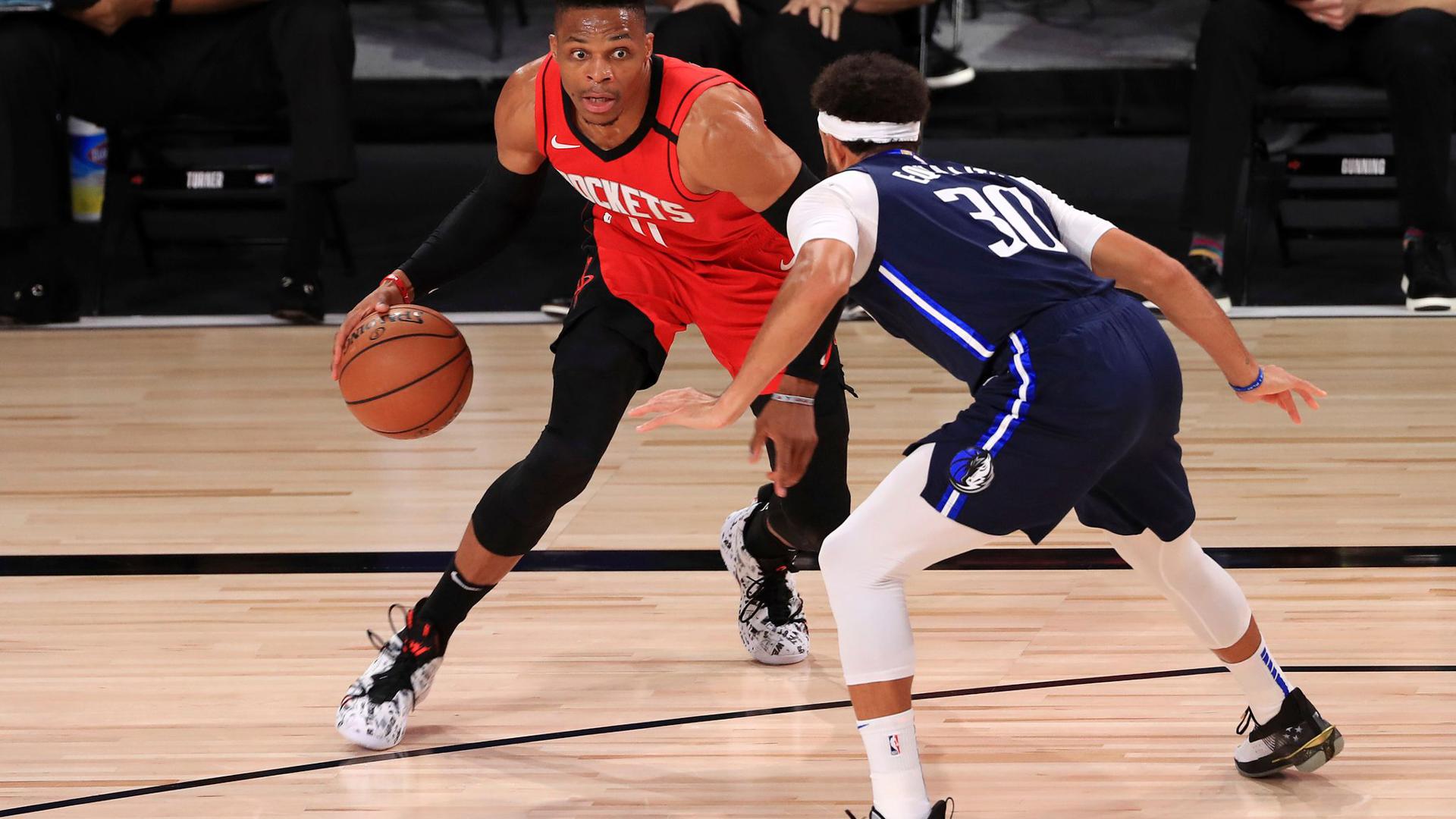 Russell Westbrook (l) von den Houston Rockets dribbelt gegen Seth Curry (r) von den Dallas Mavericks.