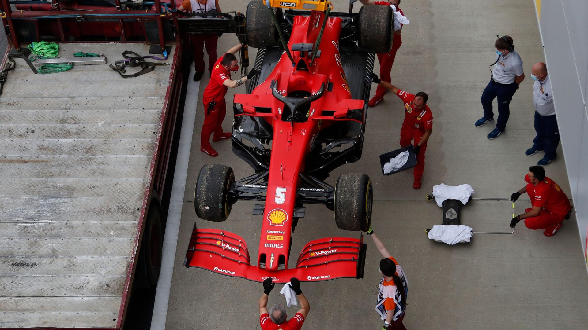 Die Boxenmannschaft von der Scuderia Ferrari überprüft am Ende des Trainings den Wagen von Sebastian Vettel.
