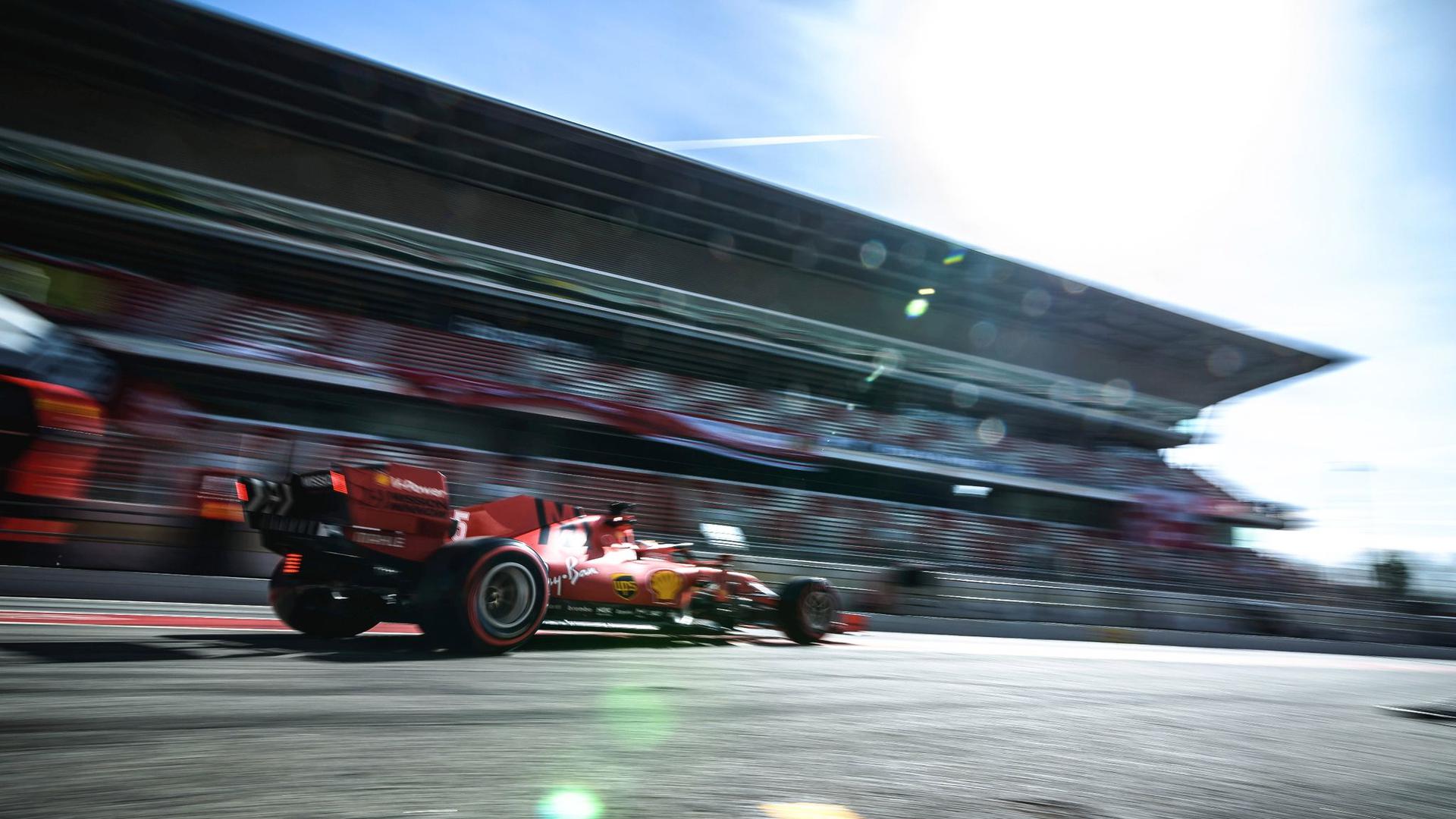 Sebastian Vettel fährt im roten Ferrari an der Tribüne des Circuit de Barcelona-Catalunya vorbei.