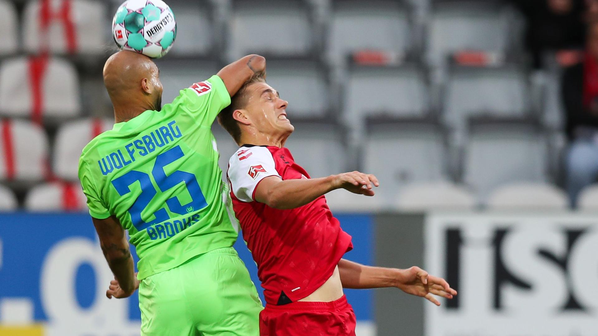 Wolfsburgs John Anthony Brooks (l) kommt vor Freiburgs Nils Petersen an den Ball.