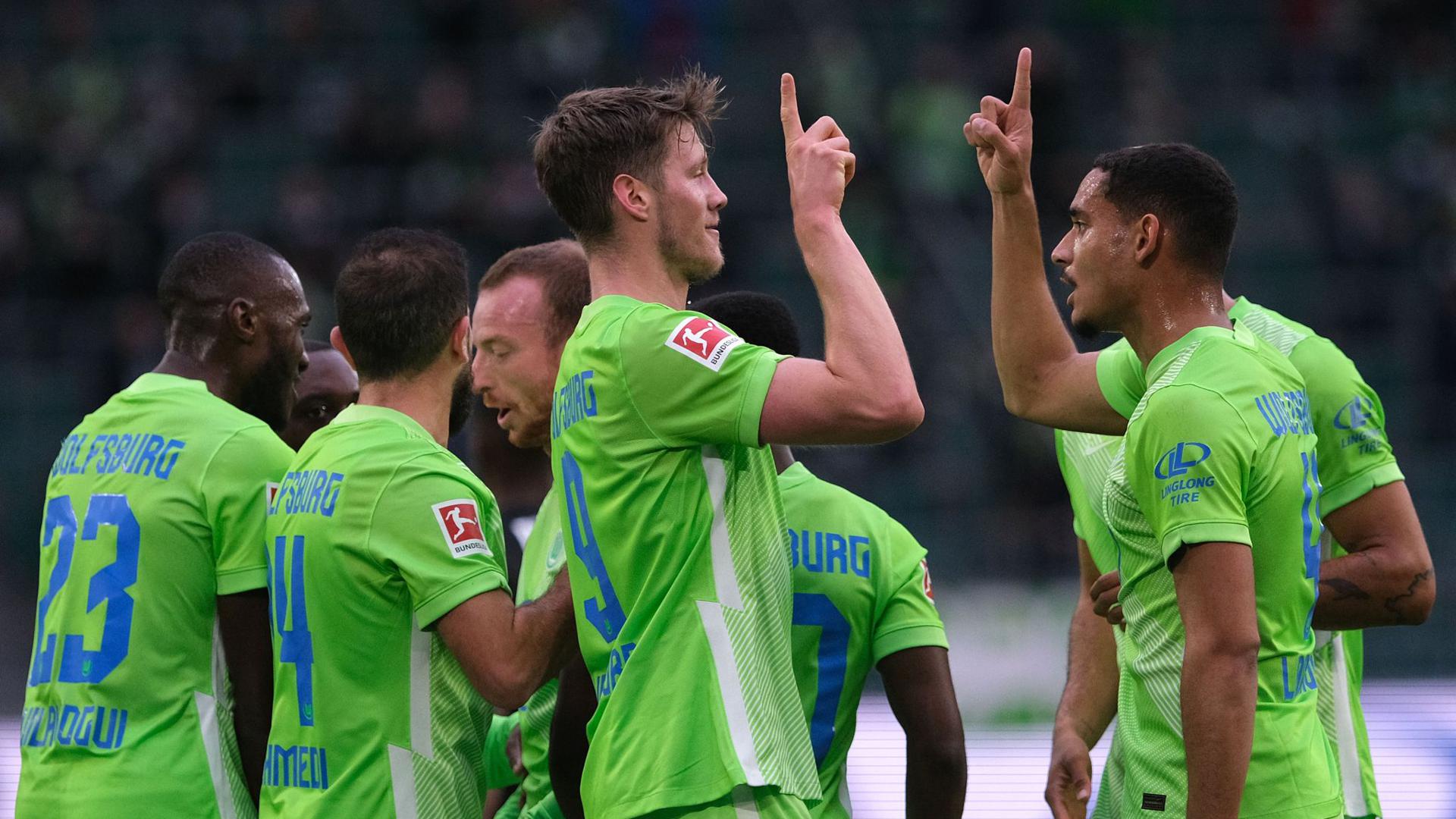 Wolfsburgs Wout Weghorst (M) bejubelt sein Tor zum 1:0 gegen Arminia Bielefeld mit Mannschaftskamerad Maxence Lacroix (r).