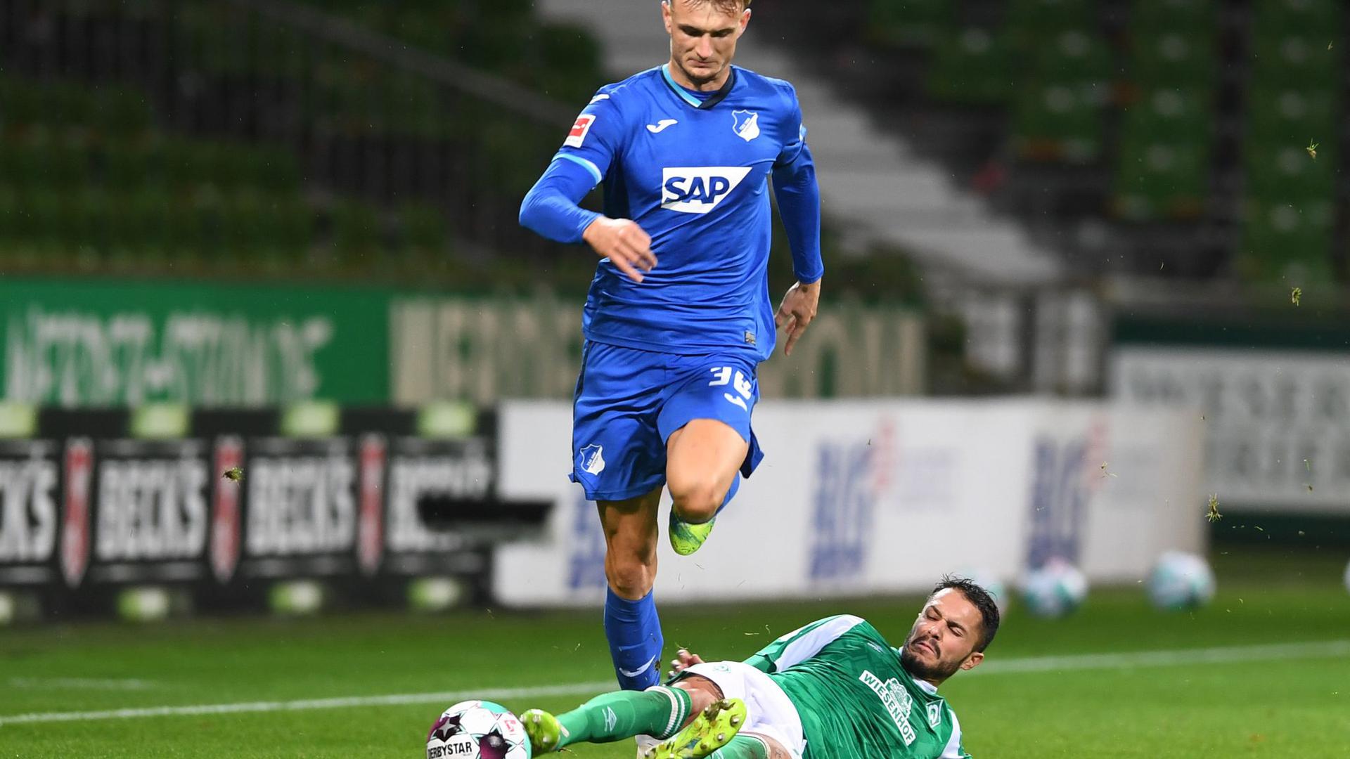 Werders Leonardo Bittencourt (r) versucht Hoffenheims Stefan Posch per Grätsche zu stoppen.