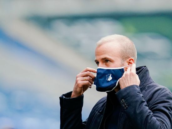 Hoffenheims Trainer Sebastian Hoeneß zieht seinen Mund-Nasenschutz auf.