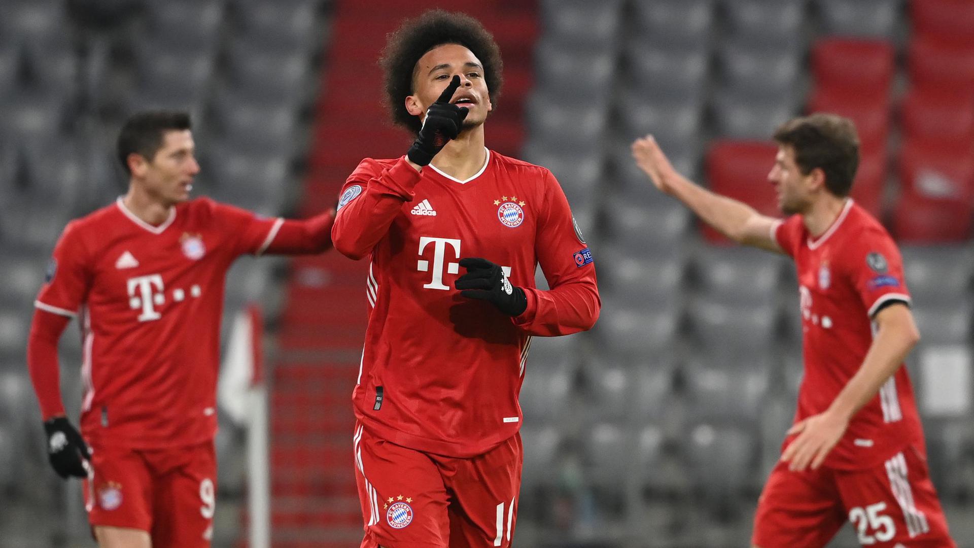 Leroy Sané (M) feiert sein Tor zum 3:0 für den FC Bayern, während hinter ihm Robert Lewandowski (l) und Thomas Müller abklatschen.