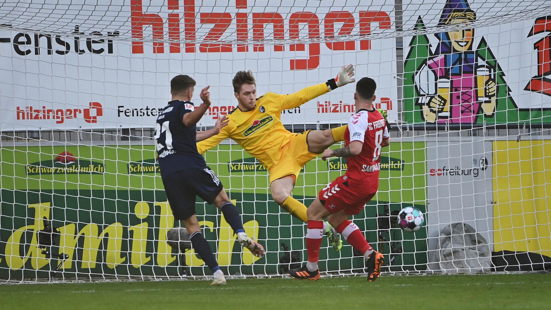 Unions Grischa Prömel (l) macht das Tor zum 0:1 - Freiburgs Torwart Florian Müller (M) kann den Ball nicht parieren.