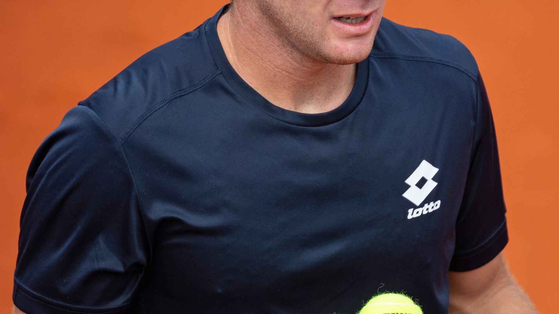 Dominik Koepfer hält zwei Tennisbälle in der Hand.