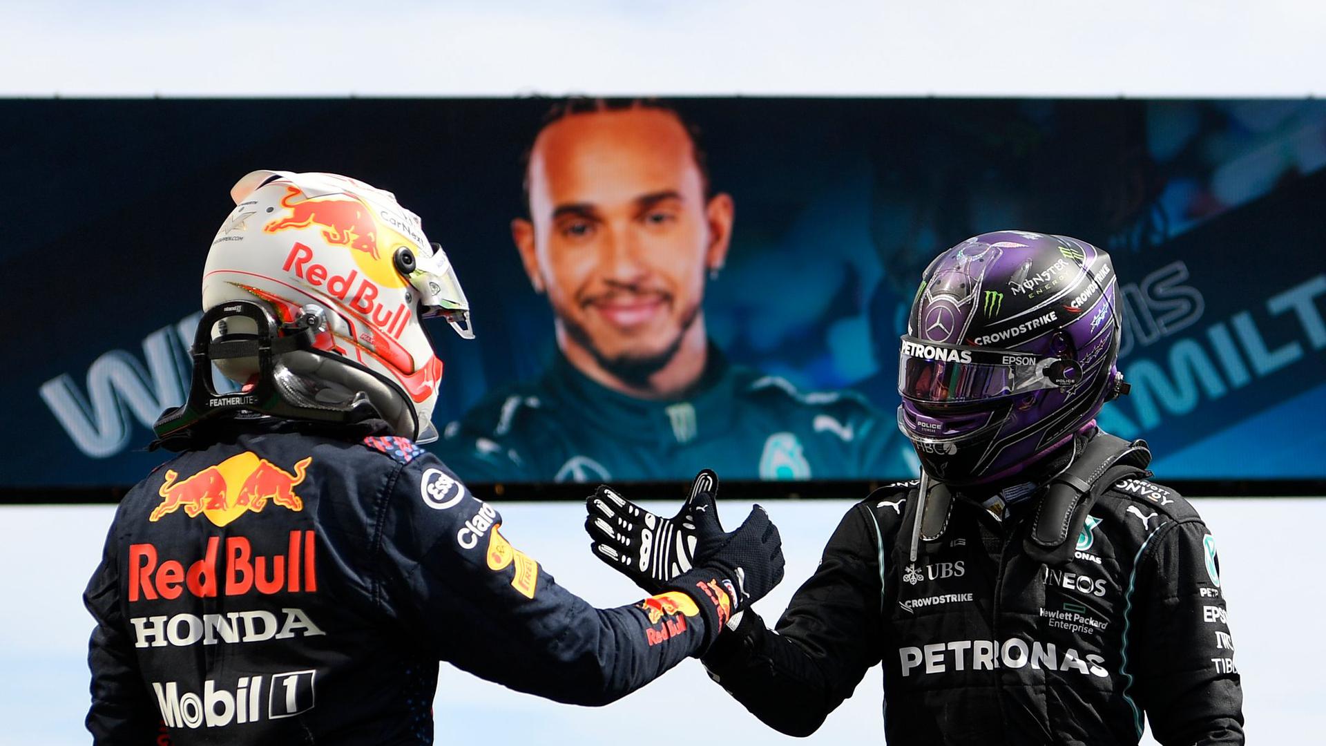 Der Brite Lewis Hamilton (r) vom Team Mercedes und der Niederländer Max Verstappen vom Team Red Bull Racing klatschen sich ab.