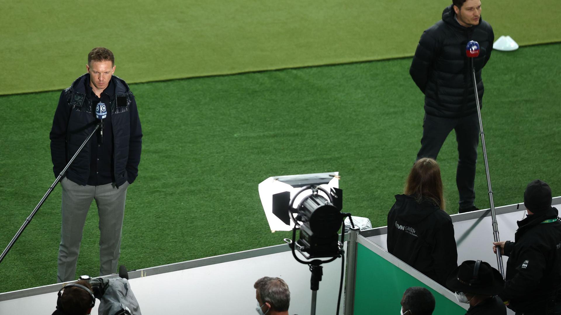 Dortmunds Trainer Edin Terzic (r) und Leipzigs Trainer Julian Nagelsmann geben vor dem Anpfiff des DFB-Pokalfinals TV-Interviews.