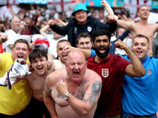 Englische Fußballfans feiern den Sieg gegen Deutschland - Schulter an Schulter - im Wembley Stadion.
