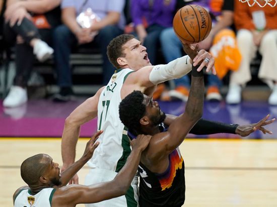 Phoenix Suns-Center Deandre Ayton (M) wird von Milwaukee Bucks-Center Brook Lopez (oben) und Forward Khris Middleton verteidigt.