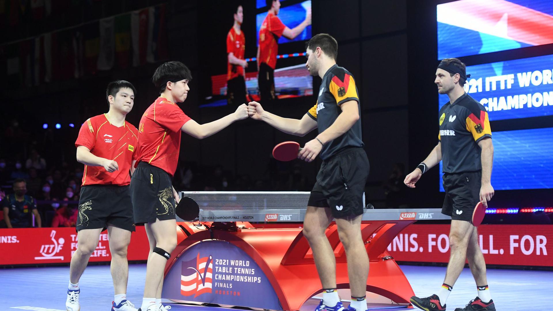 Wang Chuqin (2.v.l.) und Fan Zhendong (l) reagieren mit Patrick Franziska (2.v.r.) und Timo Boll nach dem Spiel.