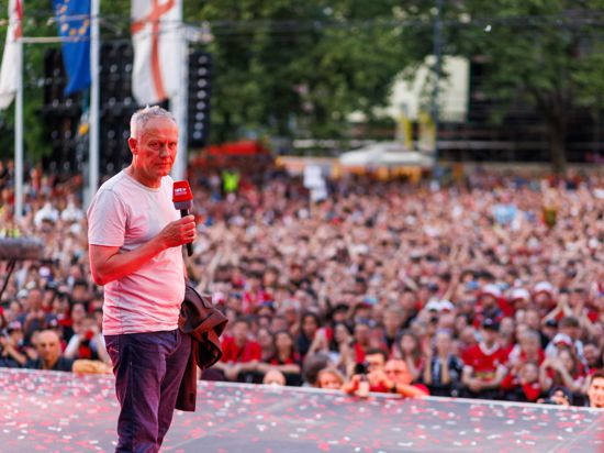 Christian Streich, Trainer des SC Freiburg, steht vor den Fans auf einer Bühne.