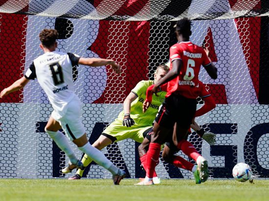 Elversbergs Jannick Rochelt (l) trifft an Leverkusens Torwart Lukas Hradecky vorbei zum 1:0.