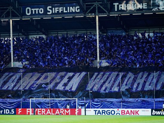 Fans halten ein Transparent mit der Aufschrift „Kämpfen Waldhof!“ in die Höhe.